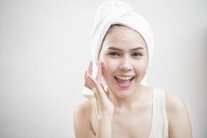 A woman is applying cream on her face photo