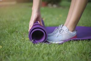 Woman is workout in outdoor with exercise mat photo