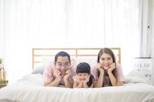 retrato de familia asiática feliz en dormitorio blanco foto