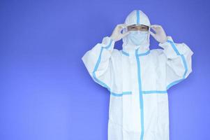 An Asian man is wearing ppe suit on purple background photo