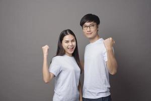 a portriat of a happy couple wearing blue shirt is enjoying over grey background studio photo