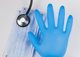 Medical masks and gloves on a white background, with a stethoscope. Coronavirus Protection Concept photo