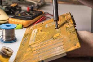 technician electronic soldering and repairing computer chip photo