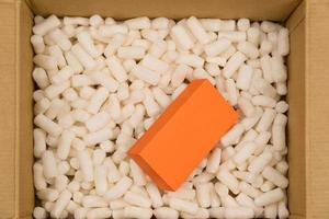 Cardboard box with styrofoam filler for safe packaging. Gift package. Top view photo