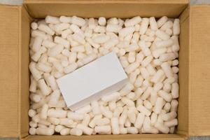 Cardboard box with styrofoam filler for safe packaging. Gift package. Top view photo