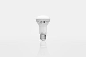 one energy saving lamp on a white background with reflection photo