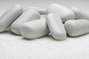 white smooth stones with water drops on light background photo