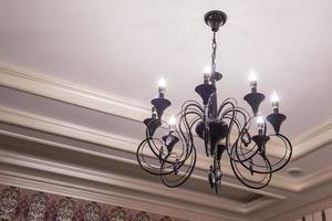 luxurious black metal chandelier hanging on the ceiling photo