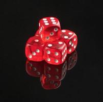 group of red playing dice on a black background with reflection, isolated. photo