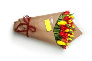 tulipanes amarillos y rojos en una cinta asociada de ramo de papel. día de San Valentín foto