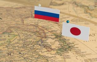las banderas de rusia y japón en el mapa mundial. fotografía conceptual, diferencias políticas debido a la isla sakhalin foto