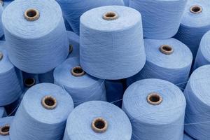 large pile of spools of blue thread. closeup photo