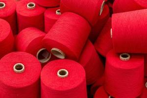 large pile of spools of red thread. closeup
