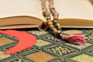 Muslim prayer beads and Quran on the prayer Mat. Islamic and Muslim concepts photo