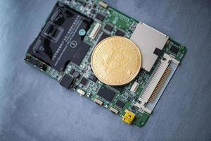 gold bitcoin on a computer Board, on a gray surface. electronic money photo