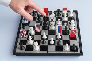 Politician's hand moves a chess piece. Conceptual photo of a political game and strategy.