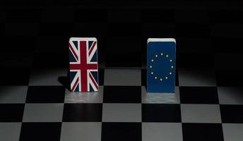 Backlit in the shadows figures and flags of the European Union and Great Britain on the chessboard. The concept of the political game and chess strategy Brexit