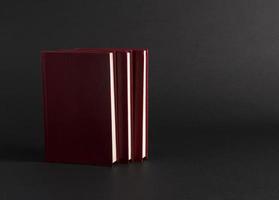 books with red cover on black background, isolated. back to school photo