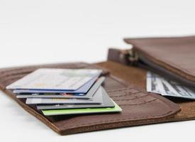 Brown wallet with credit cards and hundred dollar bills on white background photo