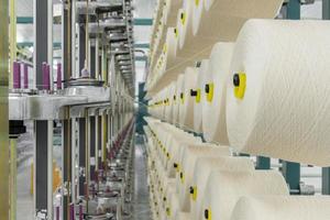 white textile yarn on the warping machine. machinery and equipment in a textile factory photo