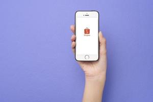 mano de mujer sosteniendo un teléfono inteligente con el logotipo de shopee en apple iphone se foto