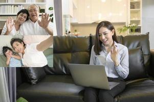 A young asian woman is using laptop computer to Video calling or Webcam to greeting her family  ,  telecommunications technology , parenthood family concept photo