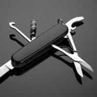 multipurpose folding knife on a black background. Swiss army knife photo