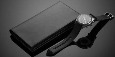 Fashionable leather men's wallet and watch on a black background photo