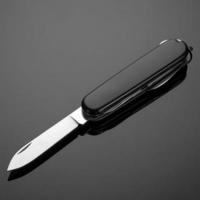 multipurpose folding knife on a black background. Swiss army knife photo