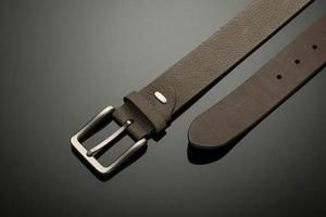 fashionable black leather men's belt on black background photo