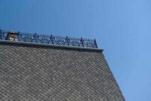 part of the roof with tiles and metal fence photo