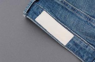 part of denim pants with back pockets and label, closeup photo