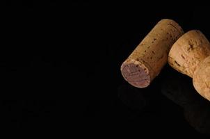 Two old wine corks on a black background with reflection photo