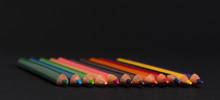 set of colored pencils on a black background isolated. back to school photo