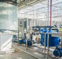 interior and equipment with pipelines and water tank in modern greenhouse photo