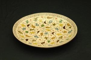 oriental antique ceramic plate on a black background photo