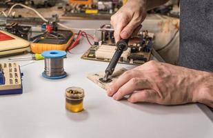 technician electrician prepares rosin soldering iron to work photo