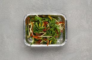 fast food in a foil box on a gray background. a healthy food close up photo