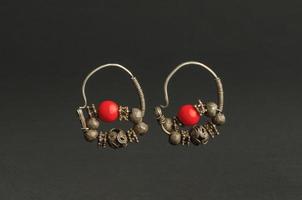 ancient antique earrings with stones on black background. Middle Asian vintage jewelry photo