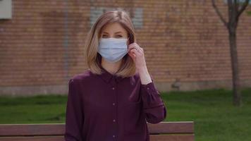 Portrait young Caucasian woman takes off medical mask. video