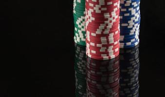 fichas de casino sobre un fondo negro con reflejo. el concepto de juego y entretenimiento. casino y póquer foto