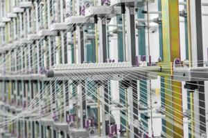 macro shot of a stretched thread. machinery and equipment in a textile factory photo