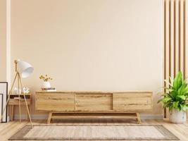 Mueble tv con pared color crema y piso de madera. foto