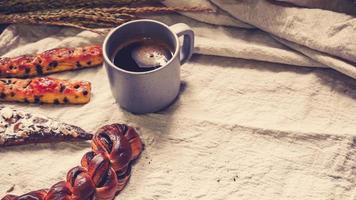panes y tostadas para el desayuno con café negro sobre fondo de sábanas blancas, desayuno saludable. fondo de idea de concepto de estilo de vida de salud de mañana foto