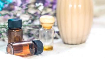 Bottle of essential oil. Herbal medicine or aromatherapy dropper bottle isolated on white background. Fresh rosemary flowers and essential oils on the table photo