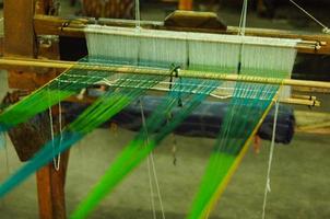 Hand made on a wooden loom manufacture of thread and fabric closeup photo