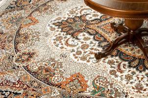 part of an antique table on a decorated oriental carpet photo