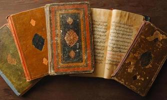 Stack of open ancient books in Arabic. Old Arabic manuscripts and texts. Top view photo