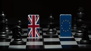 Backlit in the shadows figures and flags of the European Union and Great Britain on the chessboard. The concept of the political game and chess strategy Brexit