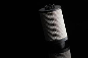 automotive filter cylindrical shape on a black background with reflection photo